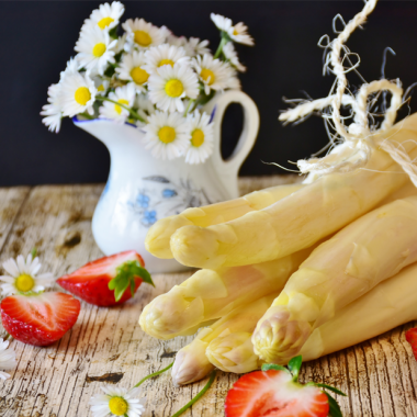 Bund Spargel mit Erdbeeren und Gänseblümchen